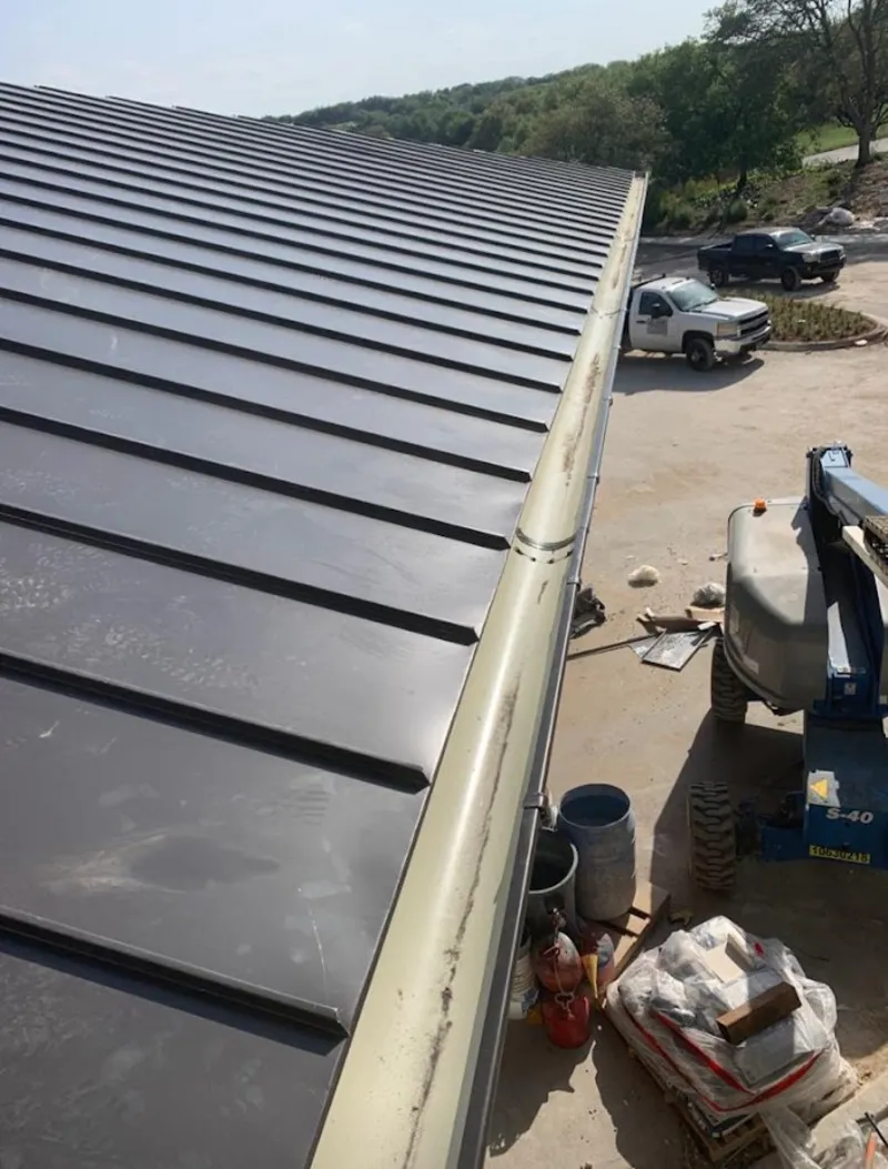 Standing seam panel and gutter detail on a metal roofing jobsite in Beaumont